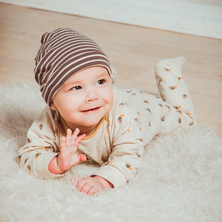 smiling baby lying on white mat