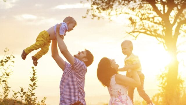 father and mother playing with boys